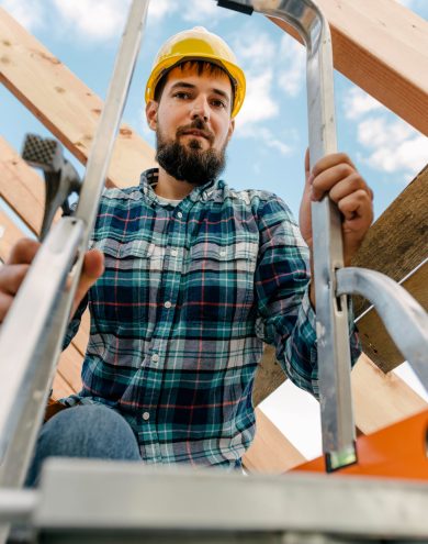 worker-with-hard-hat-using-ladder-to-build-the-roof-of-the-house.jpg